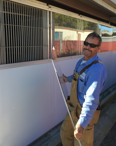 Photo of worker installing plexiglass.