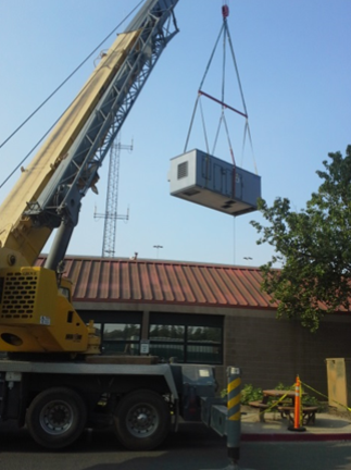 Photo of crane lifting HVAC unit.