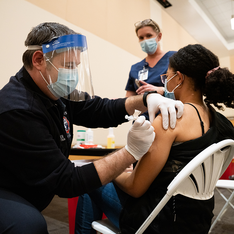 UC Davis Fire employee adminsters vaccine