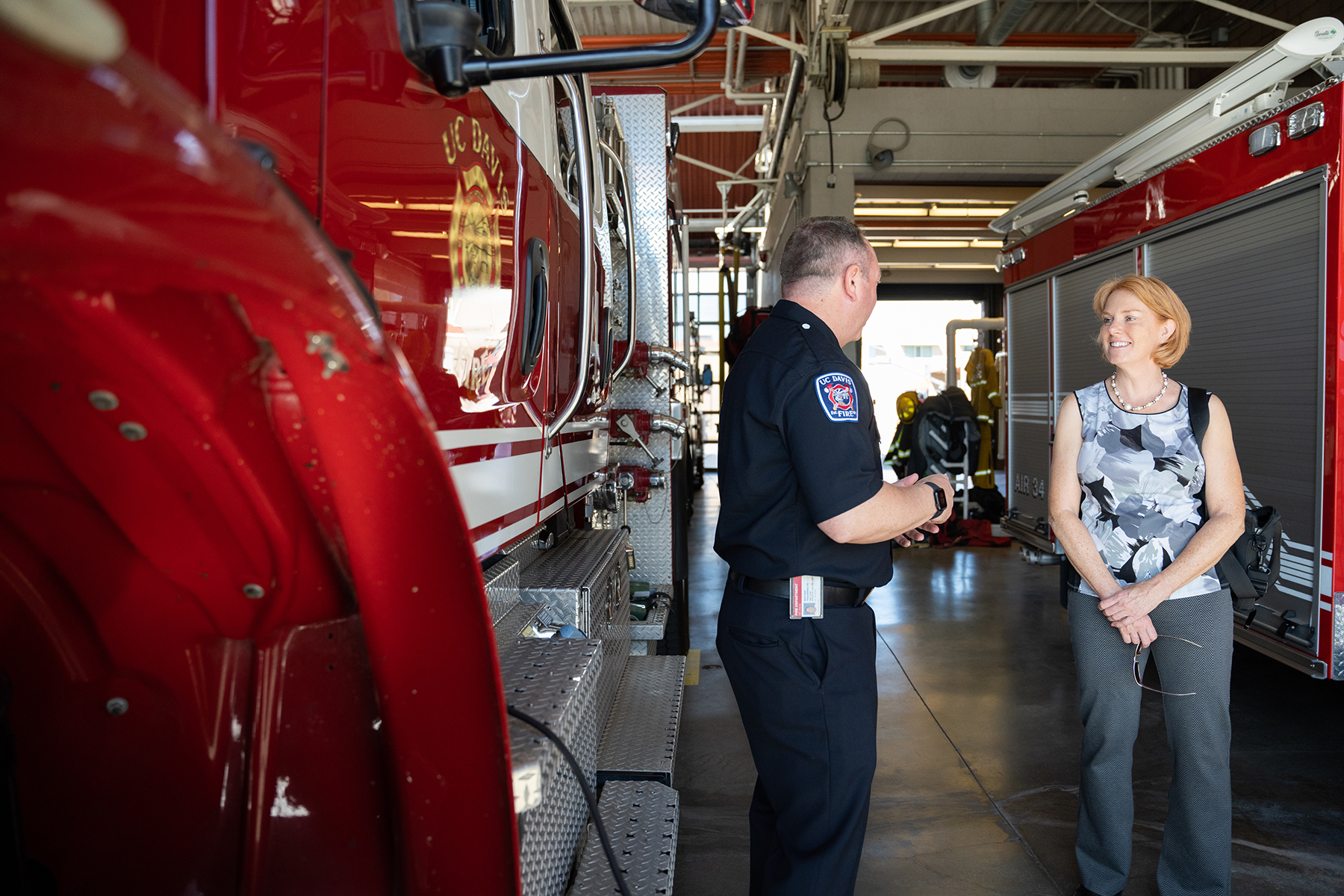 Shinnerl listens to fire department employee next to red fire engine