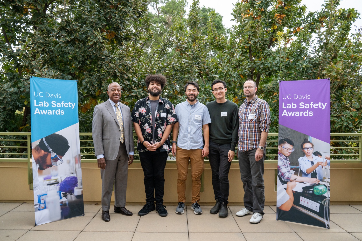 Chancellor May poses with four members of the Takamura Lab at the 2025 Lab Safety Awards