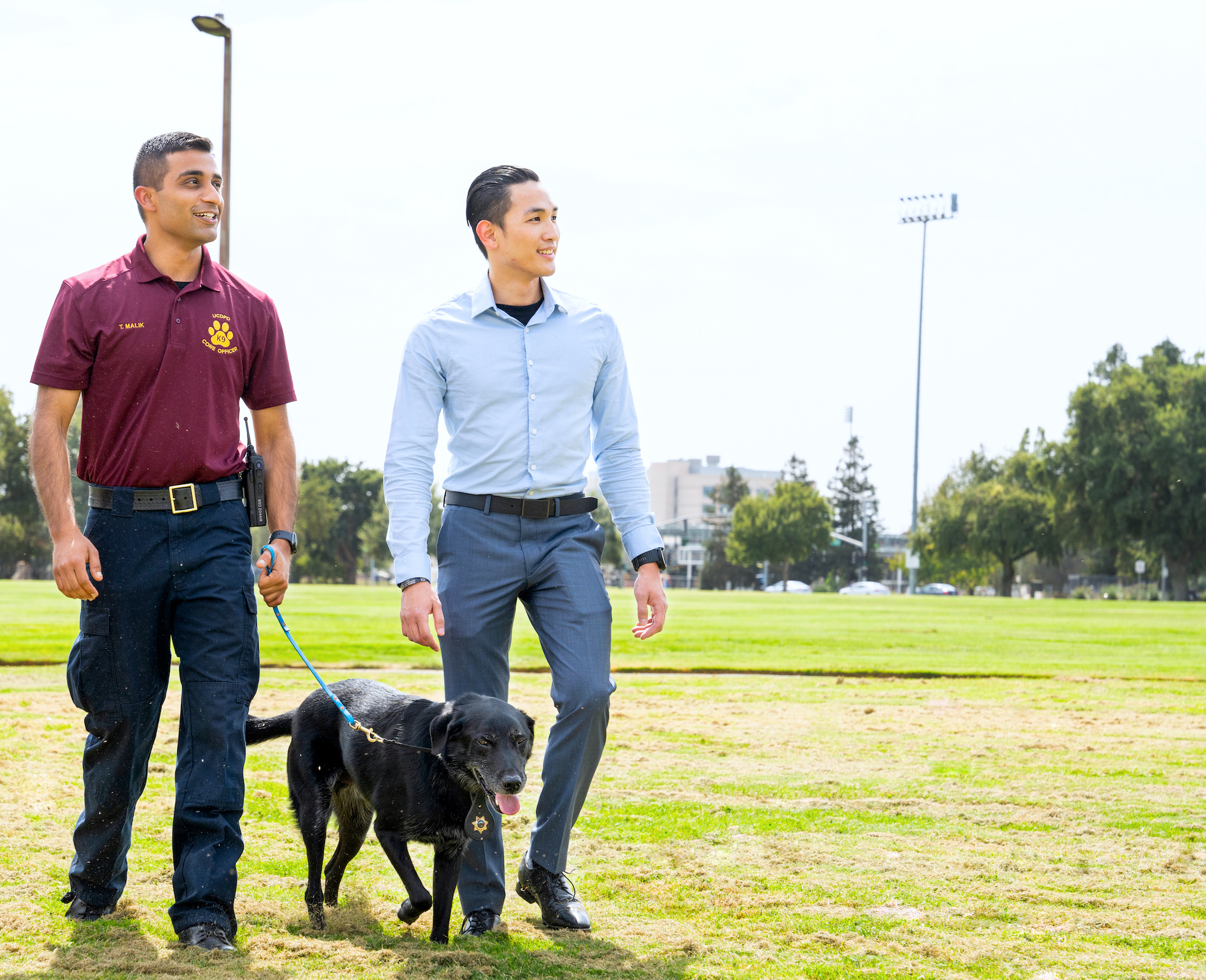 Officers Malik and Lee pose with Charlie, the K-9 dog