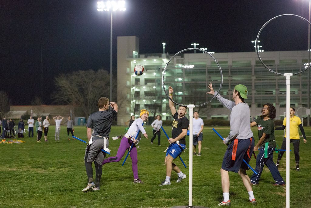 A group of people play after dark on a lit field on the UC Davis campus
