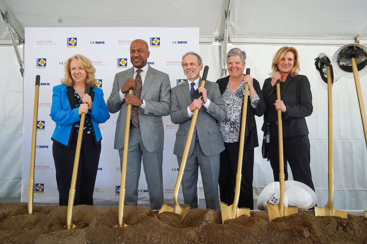 UC Davis leadership, including Chancellor Gary May and Vice Chancellor Kelly Ratliff, pose with golden shovels at the Aggie Square groundbreaking