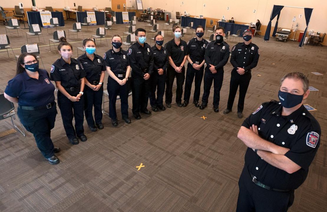 Capt. Scott Hatcher poses for a photo at the campus COVID-19 vaccine clinic with some of the Fire Department personnel who help keep the clinic running