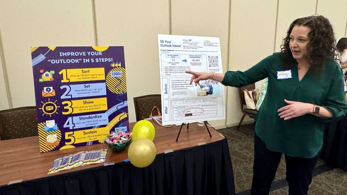Person pointing at a poster displayed on table