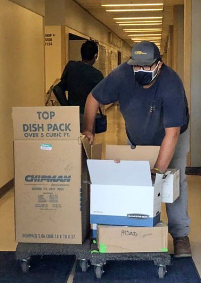 Person moves boxes out of a building