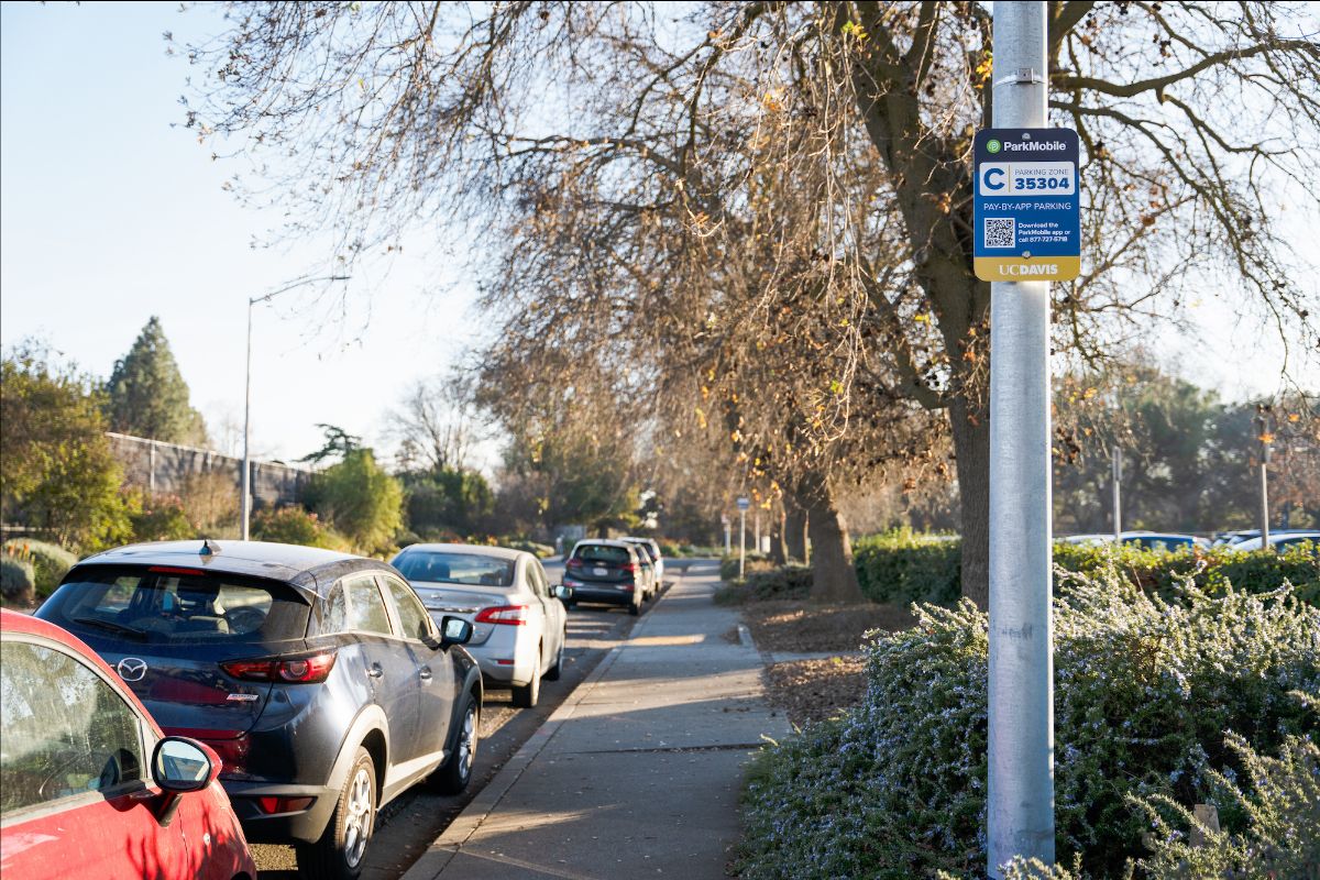 Cars parked along a street with a ParkMobile sign