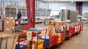 inside a warehouse space, with different colorful pushcarts loaded with packages