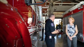 Shinnerl listens to fire department employee next to red fire engine
