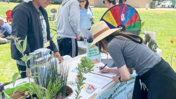 Staff member signs a form at the Arboretum and Publlic Garden table