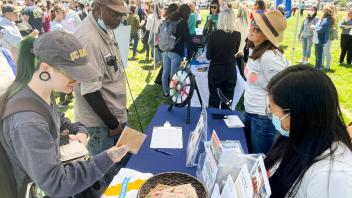 Staff members select swag at the Staff and Faculty Health and Well-being table