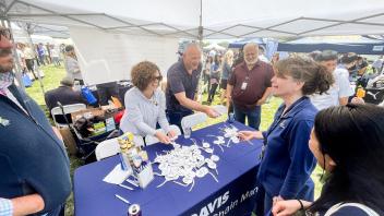 Staff members talk at the Supply Chain Management table
