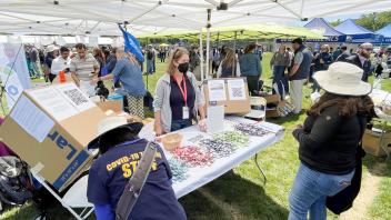 Camille Kirk speaks to a staff member at a sustainability table