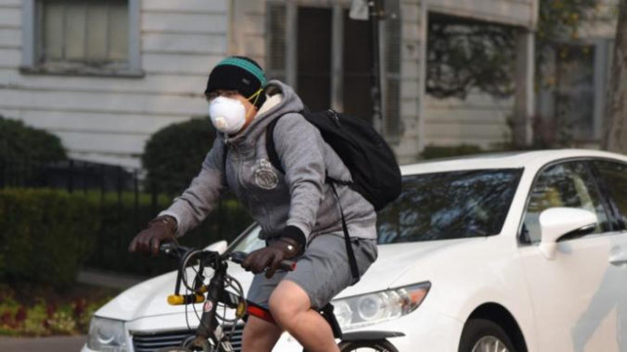 people wearing N-95 masks while riding bicycles in Davis Ca on a smoky day.