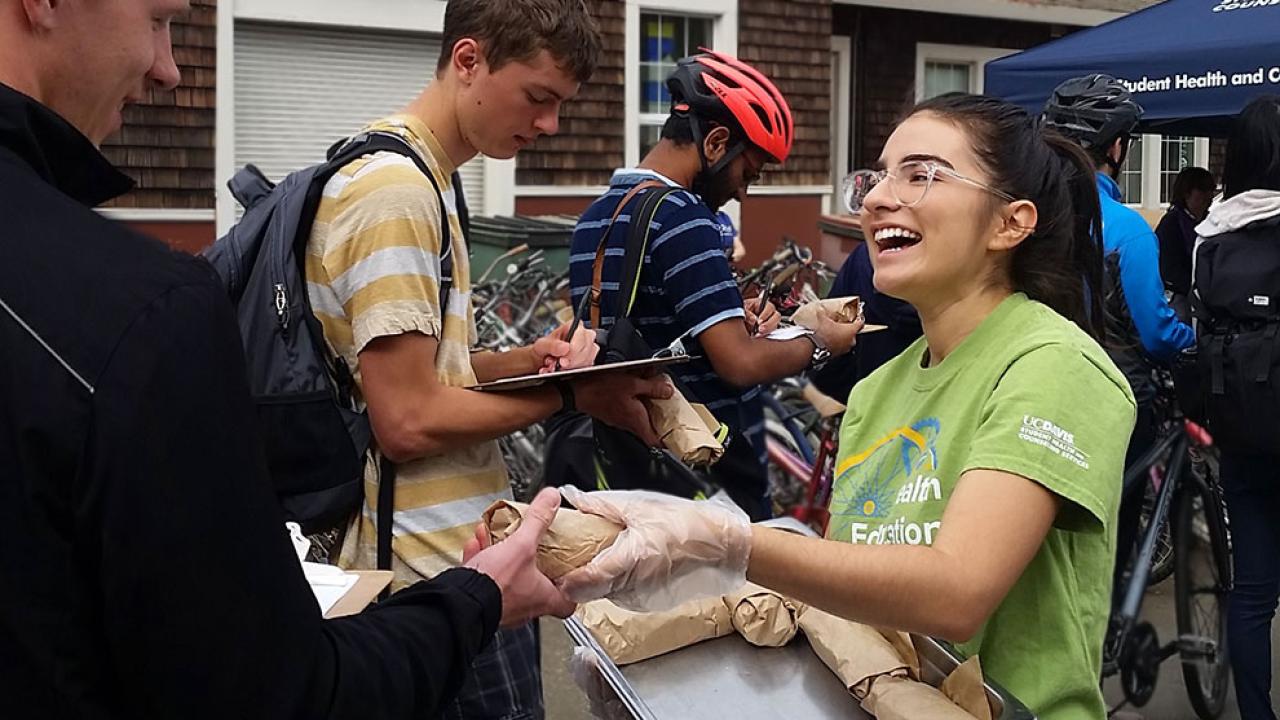 Photo of SHCS representative handing out burritos to students.