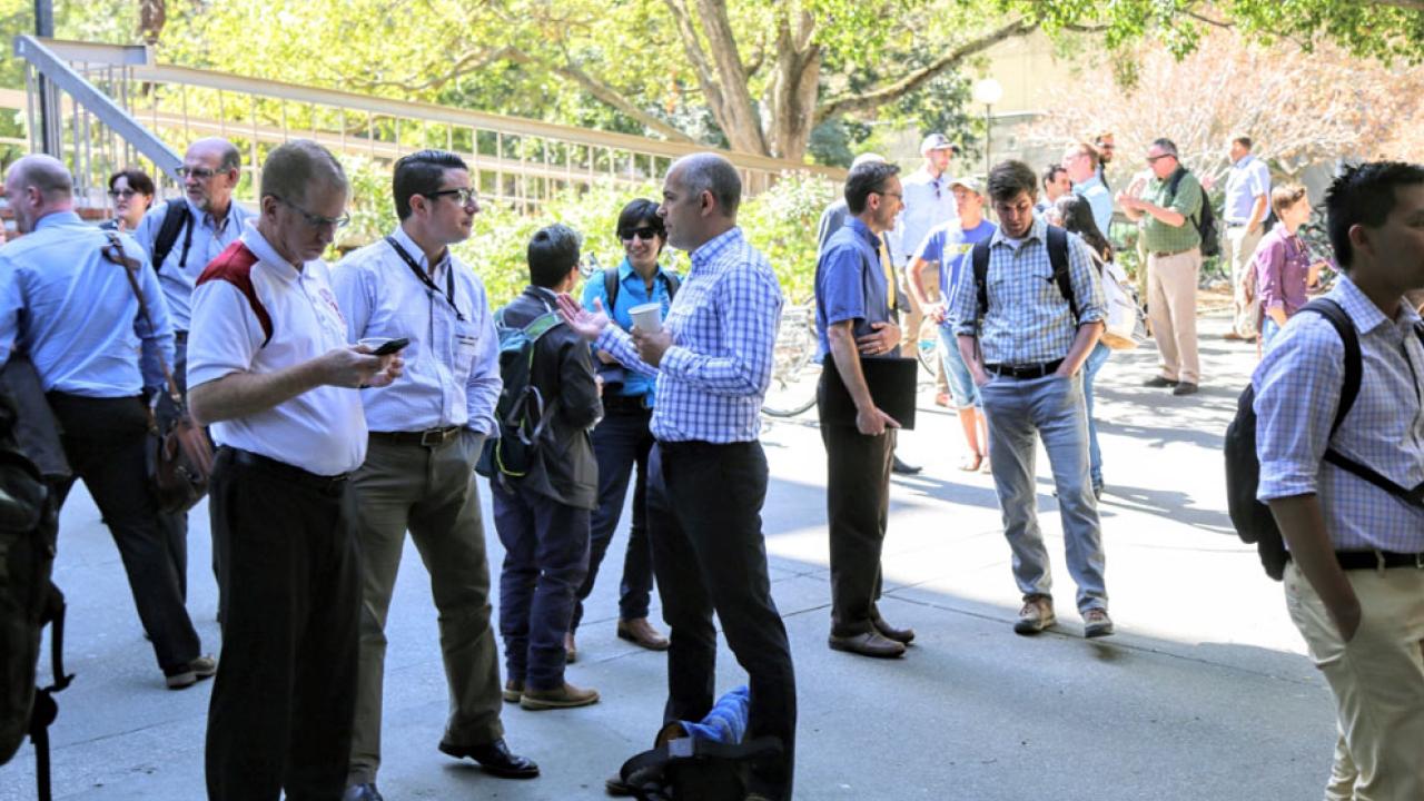 Group of summit attendees socializing outside event.