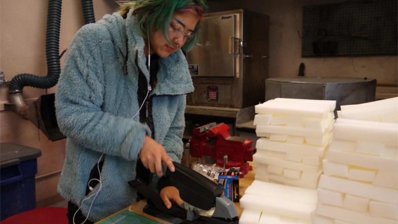 Laura Rivera, a studio art and gender, sexuality and women's studies double-major, assembles a face shield at the UC Davis Craft Center. (courtesy/Craft Center) Student stapling a face shield