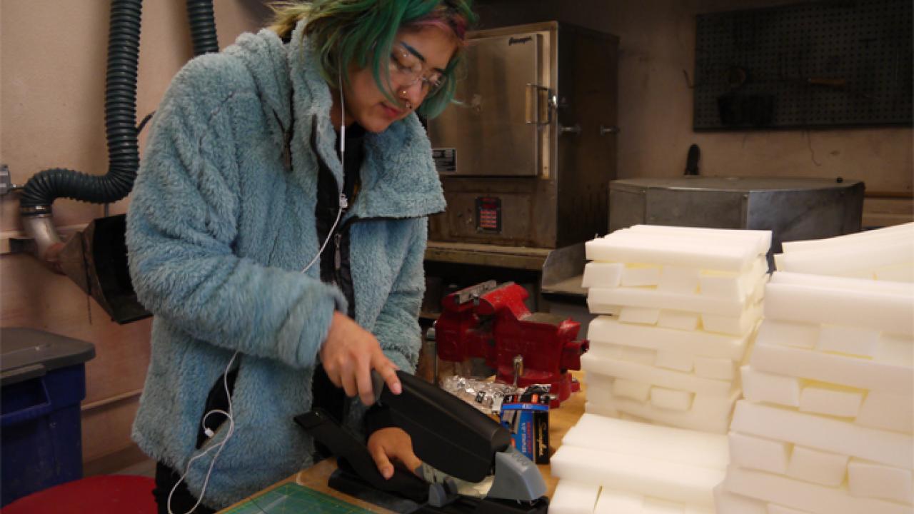 Student stapling a face shield