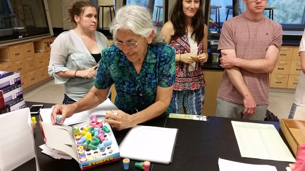 Photo of instructor and students in a lab.
