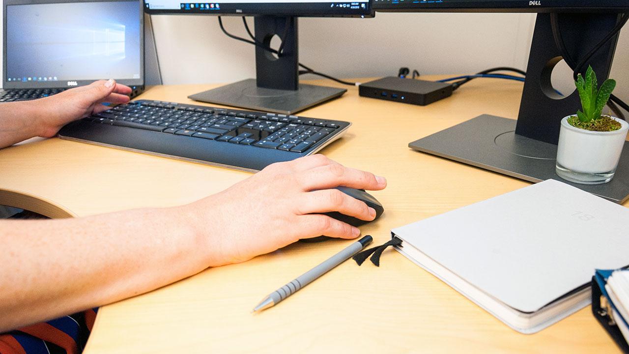 Close up photo of a person using a computer mouse.