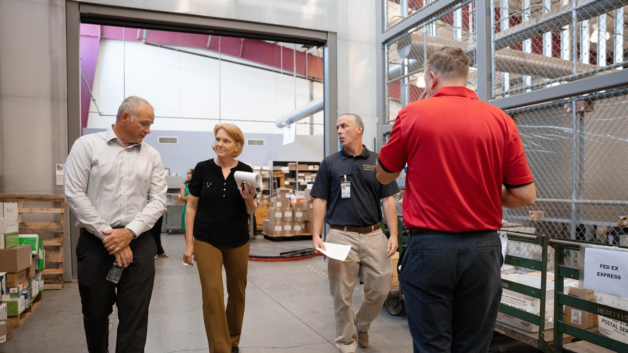 UC Davis employees walk through mail services facitility