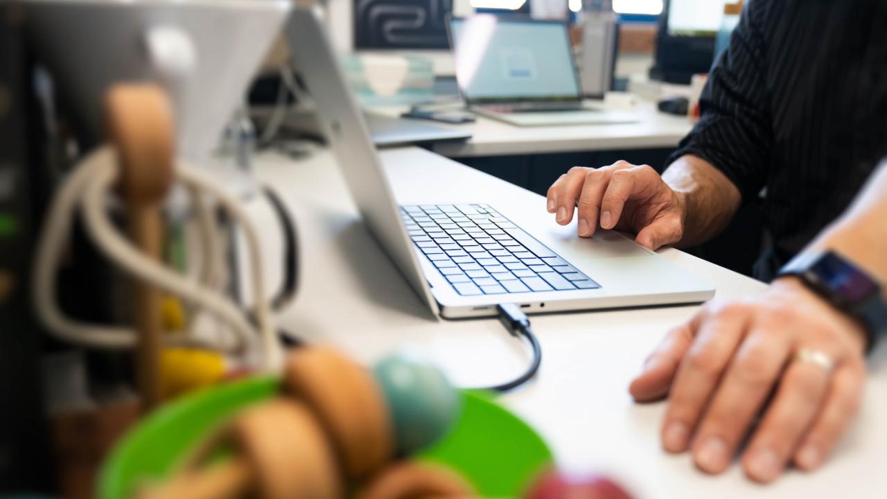 Close up of a person's hands near a laptop