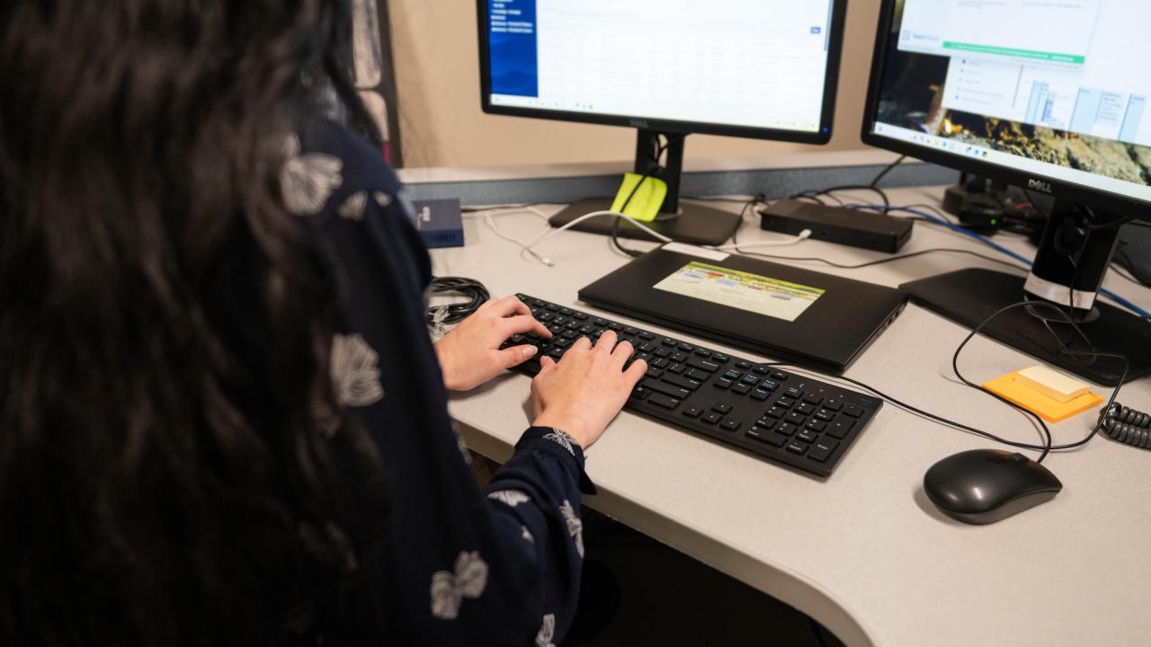 Person works at a desk with two monitors