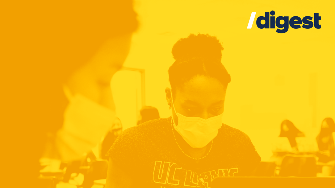 Student working on a laptop, wearing a face mask