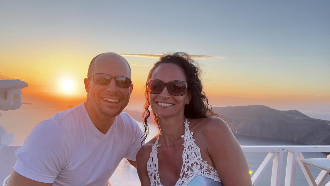 Clint Lord poses with his wife with a sunset in the background