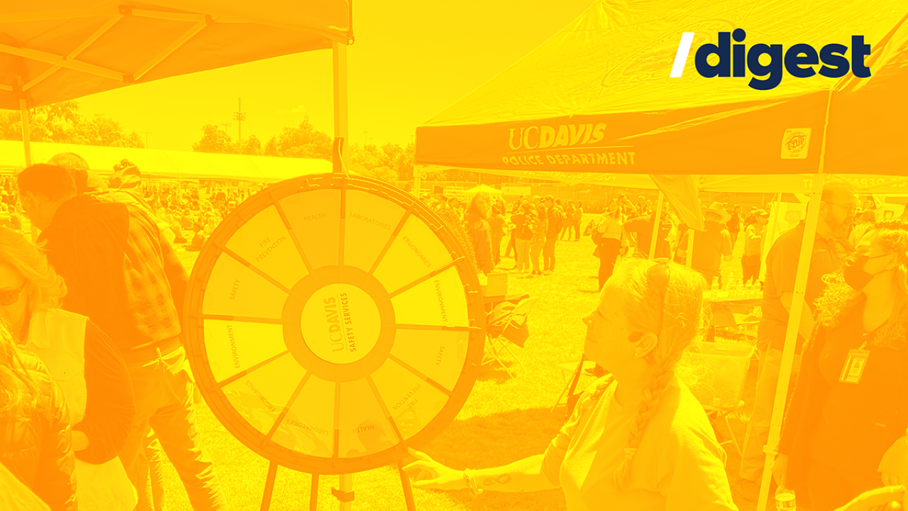 Digest header - Staff member spins a wheel at Thank Goodness for Staff 2022