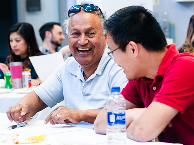 two uc davis employees talking and laughing with one another
