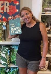 Elizabeth Cruz smiles while holding a sign that says "This is my happy place"