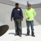 Photo of workers standing on roof.