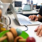 Close up of a person's hands near a laptop