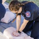 Student EMT demonstrates CPR technique on a dummy