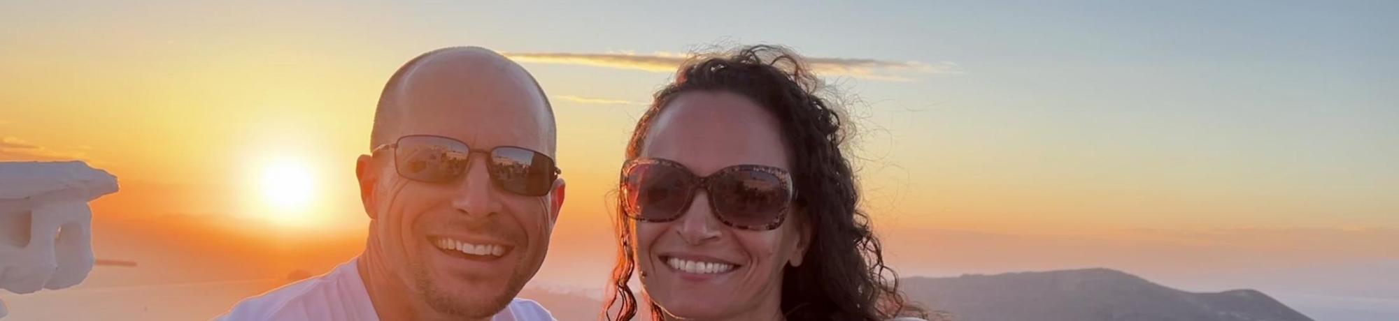 Clint Lord poses with his wife with a sunset in the background